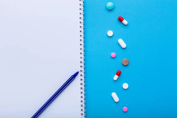 Un sacco di pillole multicolori su sfondo blu con spazio libero per il testo, come concetto di trattamento medico con prescrizione medica. — Foto Stock