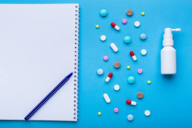 Mavi arka planda bir sürü renkli hap ve yazı için boş yer var, reçeteli tıbbi tedavi kavramı olarak..