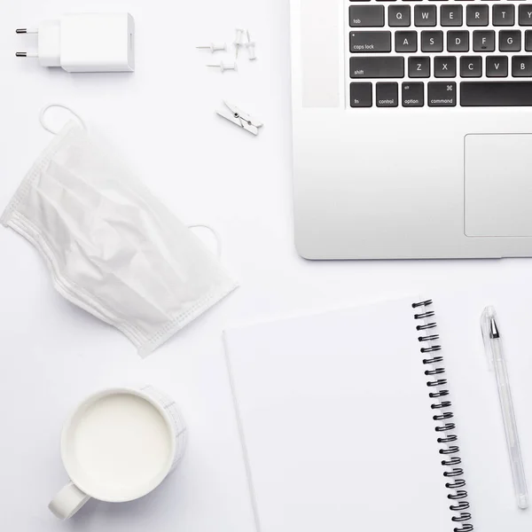 Lugar de trabajo en cuarentena con máscara y cuaderno vacío para texto. —  Fotos de Stock