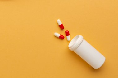 Turuncu arka plandaki hapları kapat, ağrı kesici bağımlılığı kavramını. Bir sürü hap, aşırı doz..