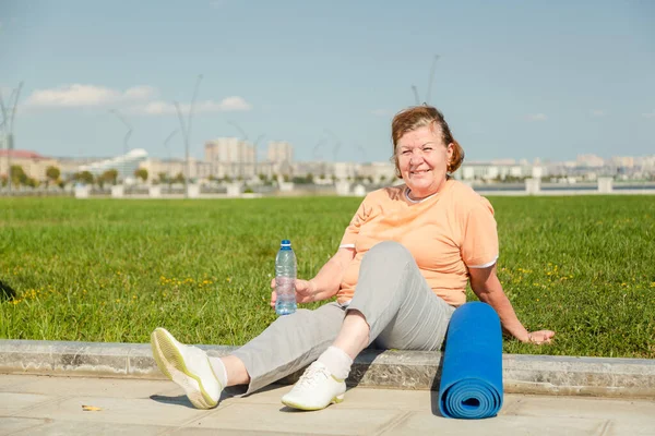 Pensionista mujer descansando después de la formación en el parque. — Foto de Stock