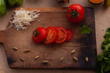 Mutfaktaki masada sağlıklı vejetaryen yemeği pişirmek için dilimlenmiş domates.