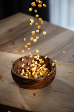 Mısır tohumlarını kaseye düşürmek, evde patlamış mısır hazırlamak. Organik malzemelerden un yapmak. Yüksek kalite fotoğraf