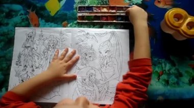 Çocuk suluboya resim yapıyor.