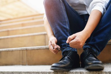 İş adamları ofiste ayakkabı bağı bağlar.