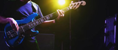 Bas gitarist veya gitarist müzik enstrümanı çalıyor (ele odaklan)