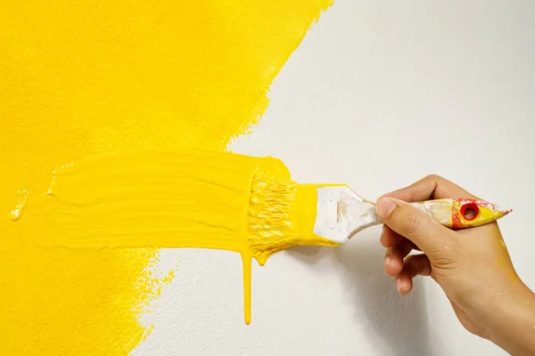 画家正在用黄色粉刷墙壁和客厅的内部 — 图库照片