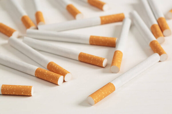 image of several commercially made pile cigarette on white  background. or Non smoking campaign concept, tobacco pattern top view.