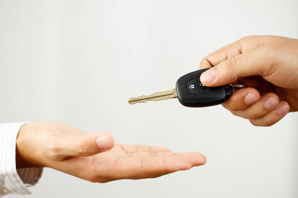 Продавец автомобилей доставляет ключи от машины клиентам в выставочный зал..