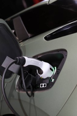 Elektrik prizi EV arabasını şarj ediyor.