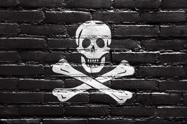 O tradicional Jolly Roger da pirataria Bandeira, pintado em tijolo wal — Fotografia de Stock