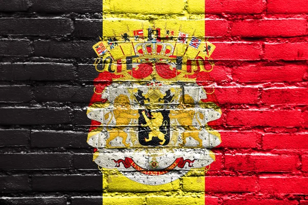 Флаг Бельгии с гербом, раскрашенный на кирпичной стене — стоковое фото