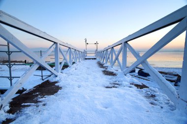 Donmuş Mietkow Gölü 'ndeki iskelede, günbatımından hemen sonra, Şubat ayındaki son derece düşük sıcaklıklarda. Polonya, Avrupa.