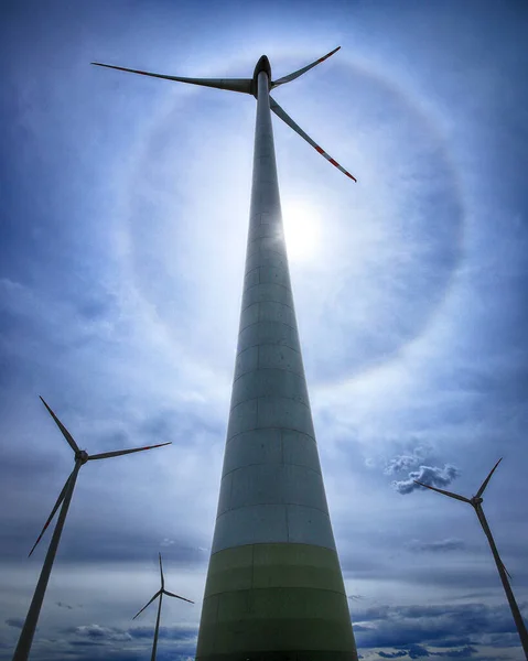 The Halo effect is an optical phenomenon in the Earth\'s atmosphere that is observed around the Sun\'s disc. It is a rainbow-colored ring that is visible around the sun. Gaj Olawski wind farm.