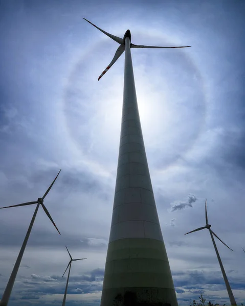 The Halo effect is an optical phenomenon in the Earth\'s atmosphere that is observed around the Sun\'s disc. It is a rainbow-colored ring that is visible around the sun. Gaj Olawski wind farm.