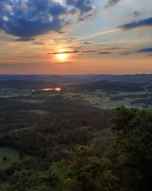Rudawy Janowickie 'de güzel bir gün batımı ve bulutlar (Polonya' nın güneybatısındaki dağlar, Avrupa). Temmuz ayı ortasında Krzyzna Gora 'dan (deniz seviyesinden 654 metre) görüntü.
