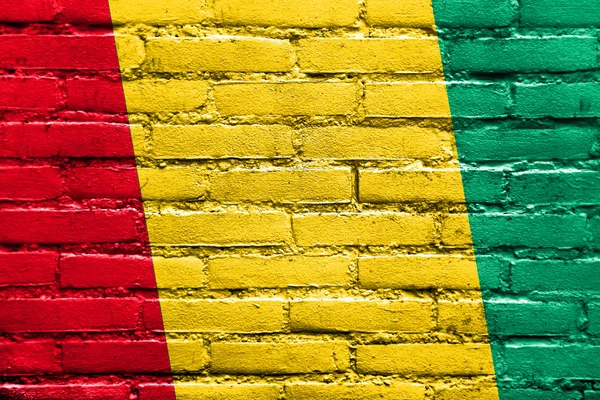 Guiné Bandeira pintada na parede de tijolo — Fotografia de Stock