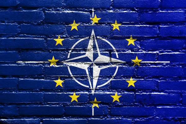 レンガの壁に描かれた nato および eu の旗 — ストック写真