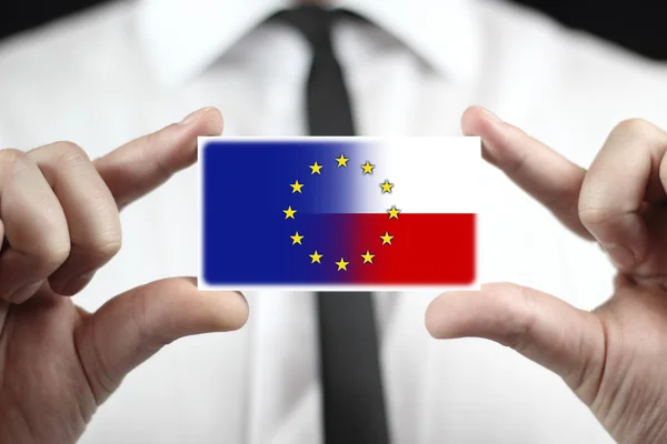 Geschäftsmann mit Visitenkarte mit polnischer und europäischer Gewerkschaftsfahne — Stockfoto