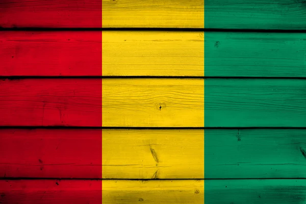 Guinea Flag on wood background — Stock Photo, Image