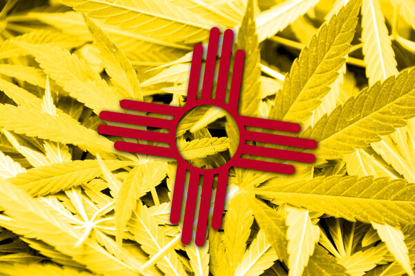 New Mexico State Flag on cannabis background. Drug policy. Legalization of marijuana