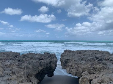Güneşin doğuşu ve kızgın dalgalar Jüpiter 'deki Blowing Rock Preserve' de, Florida sahilinde.