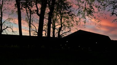 Renkli günbatımı gökyüzü ormandaki bir kulübede