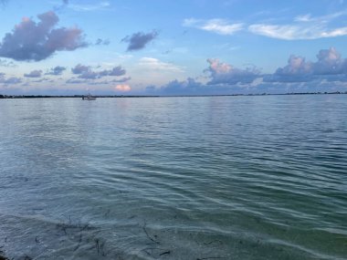 Büyük turuncu güneş plaj manzarasının arkasında batıyor.