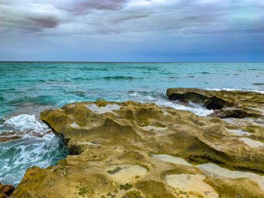 Dalgalar yazın kayalıklara vurur.
