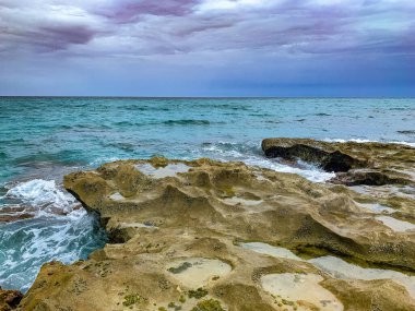 Dalgalar yazın kayalıklara vurur.