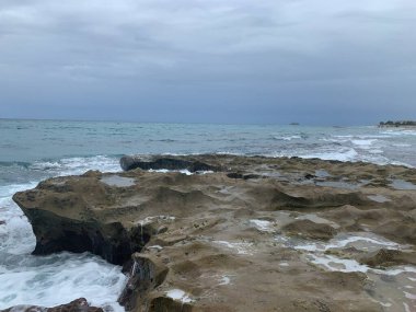 Dalgalar yazın kayalıklara vurur.