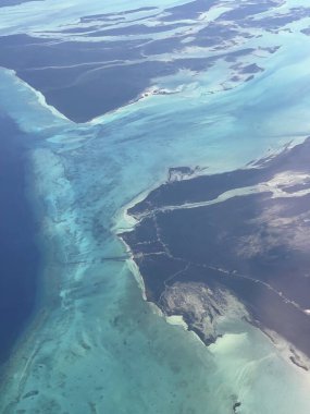 Turkuaz lagün, mercan resifleri, kum yığınları ve temiz sığ sulardaki koyu mangrov adaları ve doğal deniz manzaralı tropikal kıyı şeridi manzarası..