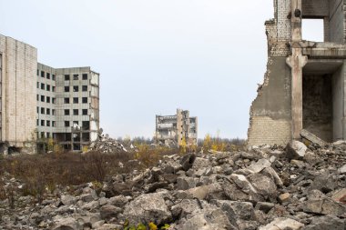 Bulanık sisli, tarafsız gri gökyüzüne karşı beton gri enkaz yığını olan harabe bir bina. Arkaplan