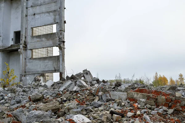 Разрушенное Здание Грудой Бетонных Серых Обломков Против Нейтрального Серого Неба — стоковое фото