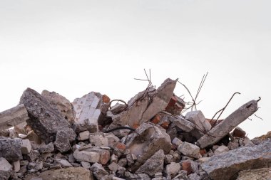 Harap olmuş bir binanın beton parçaları. Gri gökyüzünün arka planına demirle yakın plan. Arkaplan.