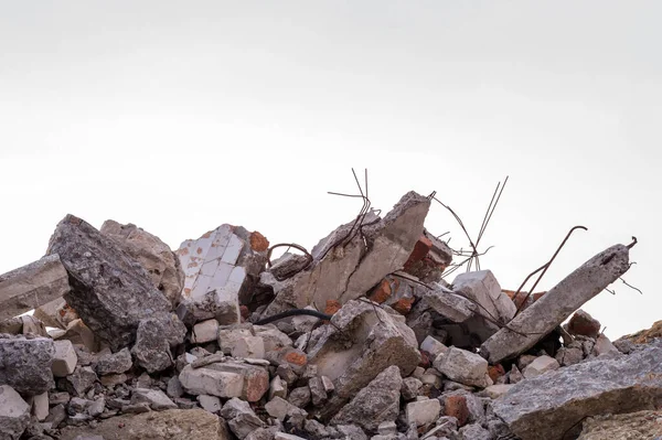 Harap olmuş bir binanın beton parçaları. Gri gökyüzünün arka planına demirle yakın plan. Arkaplan.