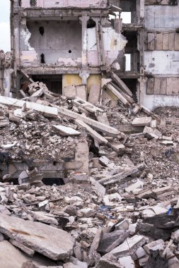Önünde büyük bir temel yığını olan harabe bir binanın kalıntıları. Arkaplan.