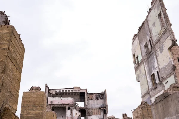 一座被毁建筑的残骸 地基堆积如山 还有一堵墙的残骸 在灰蒙蒙的天空中映衬着前景 低角度 — 图库照片