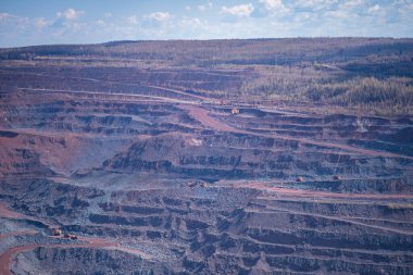 Demir cevheri ocağının çeşitli pembe ve mavi kuartzit tonlarına ve cevherlerin çıkarılması için teraslara sahip bir kısmının görüntüsü. Boşluğu kopyala.