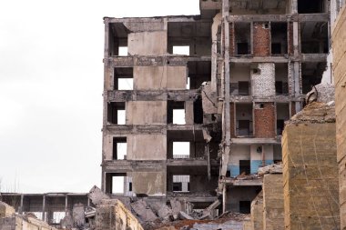 Önünde büyük temeli olan bulutlu gri gökyüzüne karşı yıkılmış bir bina. Arkaplan.