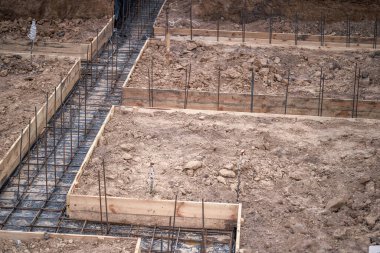 Evin inşaatı, beton temeli takviyenin kaynaklı yapısına dökme hazırlığıyla başladı. Arkaplan.