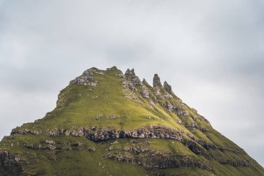 Arka planda ikonik Drangarnir kapısı, Tindholmur ve benim kines adası, Faroe Adaları ile üst görünüm dikey kompozisyonu