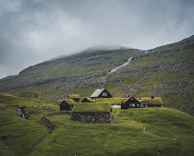 Faroe adalarındaki Saksun köyündeki şelaleler. Etrafta insan yok, geleneksel taş evler..