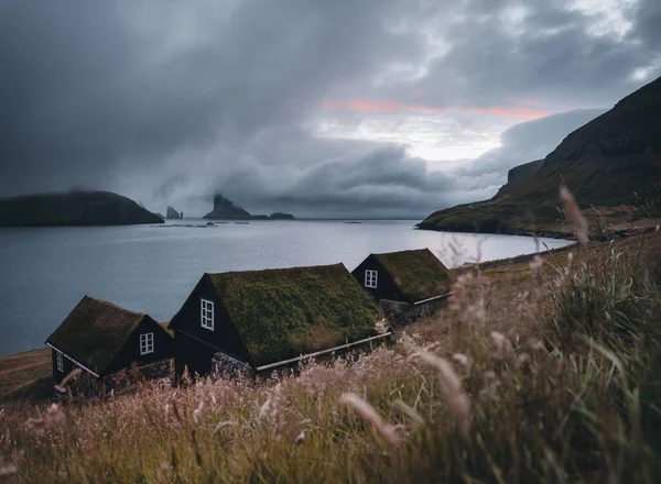 Bour village Grass-covered picturesque houses at the Faroese coastline in the village Bour with view onto Dranganir and Tindholmur during spring. — Stock Photo, Image