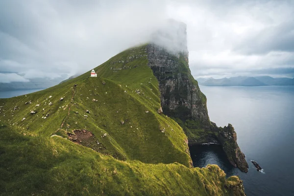 位于丹麦、欧洲法罗岛上的卡卢尔灯塔的卡卢塞岛。悬崖峭壁上的云彩，碧绿的大西洋和壮观的景色. — 图库照片