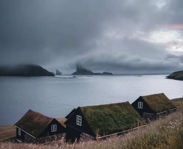 Bour village Grass-covered picturesque houses at the Faroese coastline in the village Bour with view onto Dranganir and Tindholmur during spring. — Stock Photo, Image