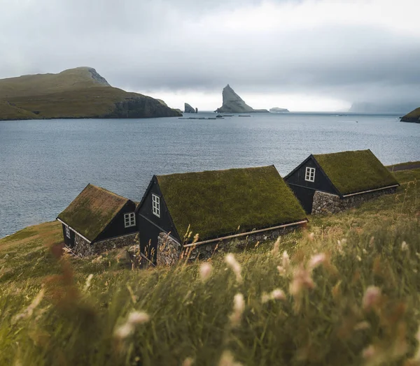 Bour χωριό Grass-καλύπτονται γραφικά σπίτια στις ακτές των Φερόων Νήσων στο χωριό Bour με θέα Dranganir και Tindholmur κατά τη διάρκεια της άνοιξης. — Φωτογραφία Αρχείου