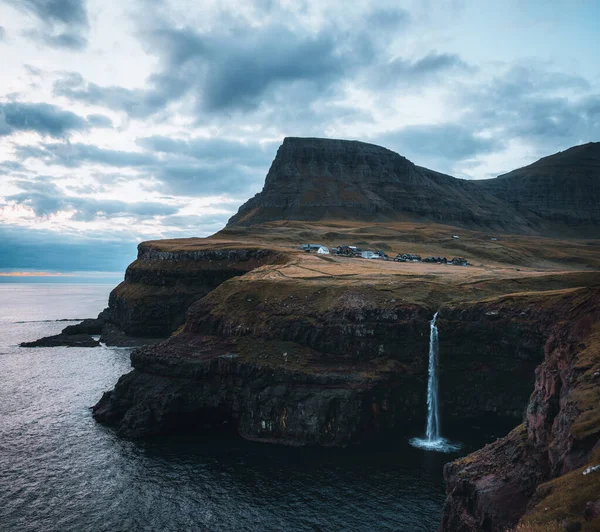 Gasadalur Dorf und Mulafossur seinen ikonischen Wasserfall bei Sonnenuntergang im Sommer mit blauem Himmel. Vagar, Färöer, Dänemark. Raue See im Nordatlantik. — Stockfoto