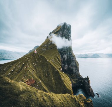Danimarka, Avrupa 'daki Faroe adalarında Kallur deniz feneri olan Kalsoy Adası. Yüksek uçurumların üzerindeki bulutlar, turkuaz Atlantik okyanusu ve muhteşem manzaralar..