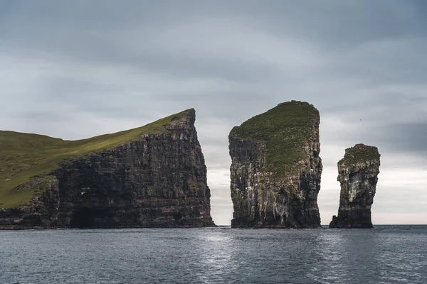 Close-up de famoso penhasco de Drangarnir com ilhas Tindholmur no fundo tomado durante a caminhada matinal na primavera na costa das Ilhas Faroé, Dinamarca, Europa — Fotografia de Stock